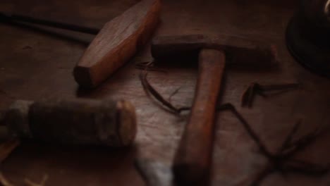 Nahaufnahme-Der-Hände-Eines-Landmanns,-Der-In-Seinem-Alten-Arbeitszimmer-Mit-Holz-In-Der-Nähe-Einer-Vintage-Öllaterne-Aus-Metall-An-Einem-Hölzernen-Arbeitsplatz-Arbeitet