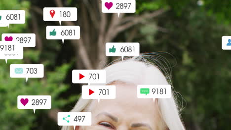 animación de iconos y números de redes sociales sobre mujer caucásica en el jardín