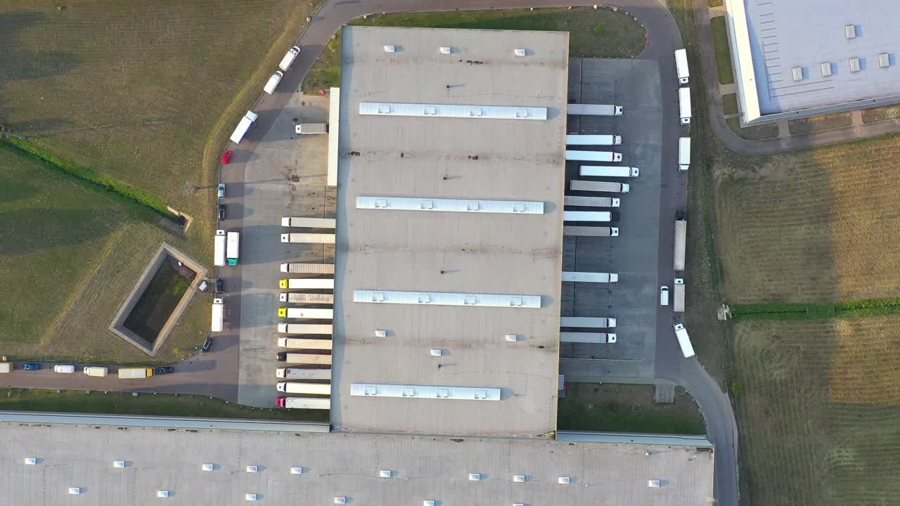semirremolque con remolque de carga viaja a lo largo de un estacionamiento de un almacén en el parque logístico