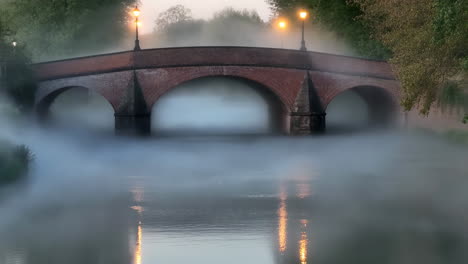 misty brick bridge with lantern reflections