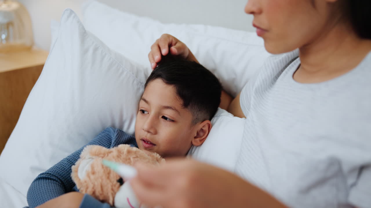 어머니가 아이의 체온을 확인하고 있습니다.