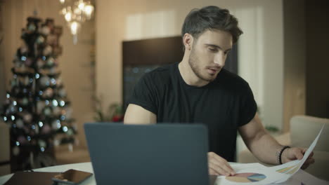 Business-man-working-with-papers-at-winter-holidays-in-home