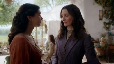 two women in vintage clothing in a garden