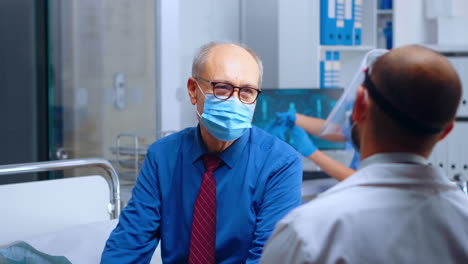 médico hablando con el paciente con máscara