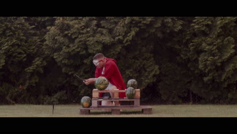 man cutting watermelons with a knife