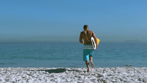 Un-Hombre-Guapo-Con-Una-Tabla-De-Surf-Corriendo-Hacia-El-Mar.