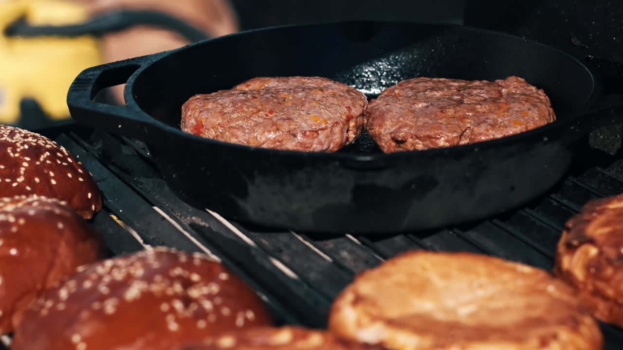 Frying patties and burger buns in a frying pan and grill. BBQ