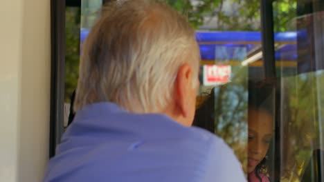 commuter taking ticket from driver in bus 4k