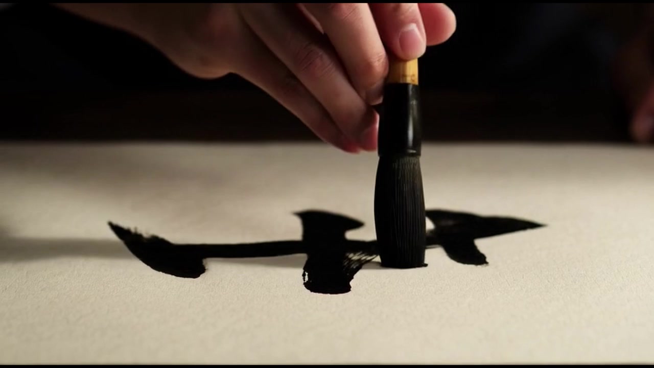 Artista che pratica calligrafia tradizionale giapponese con pennello a inchiostro