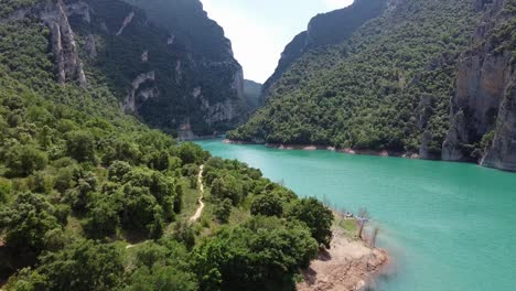 Congost-de-Mont-Rebei-Canyon,-Catalonia-and-Aragon,-North-Spain---Aerial-Drone-View-of-The-Hike-Trail,-Gorge-and-the-Blue-Noguera-Ribagorzana-River-Lake