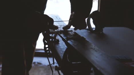 slow-motion shot of person waxing skis, scraping wax off of ski