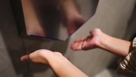 hands being dried under an automatic dryer