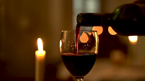 Una-Escena-De-Cena-Romántica-A-La-Luz-De-Las-Velas-Cobra-Vida-Cuando-Un-Camarero-Sirve-Con-Gracia-Vino-Tinto-Aterciopelado-En-Una-Copa-Que-Espera,-Preparando-El-Escenario-Para-Una-Velada-De-Calidez-E-Intimidad.