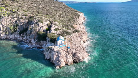 Um-Eine-Kleine-Griechisch-orthodoxe-Kirche-Auf-Einem-Felsen-Am-Meer-Herumfliegen