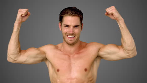 sportsman raising his arms on grey background