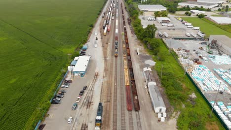 Vista-Aérea-De-4k-Que-Muestra-Varios-Trenes-Estacionados-En-Una-Estación-De-Tren-Esperando-Para-Salir