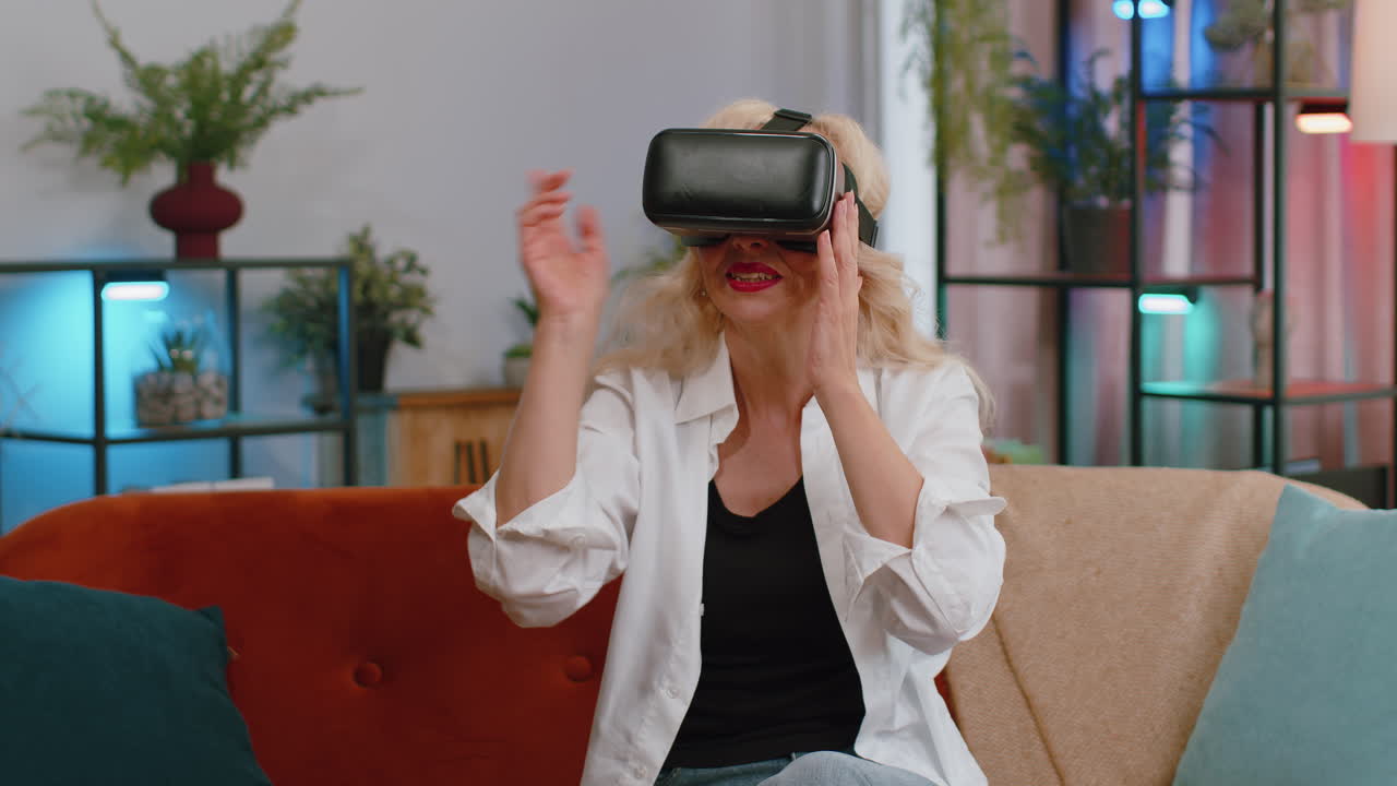 mujer de la tercera edad usar realidad virtual tecnología futurista auriculares jugar simulación 3d videojuego en casa