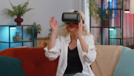 Ältere-Frau-Nutzt-Virtual-Reality-Headset-Mit-Futuristischer-Technologie,-Spielt-Simulation-3D-Videospiel-Zu-Hause