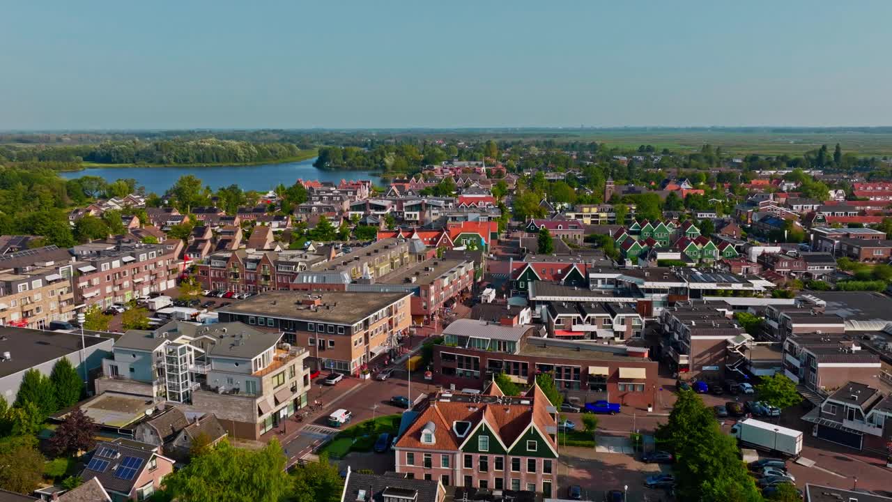 Drone footage of Landsmeer village in the Netherlands, featuring the peaceful town, church, and the large lake of nature reserve Het Twiske, showcasing the beautiful Dutch countryside