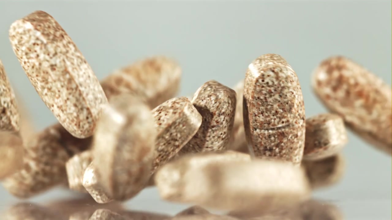 Brown Speckled Pills Falling in Slow Motion