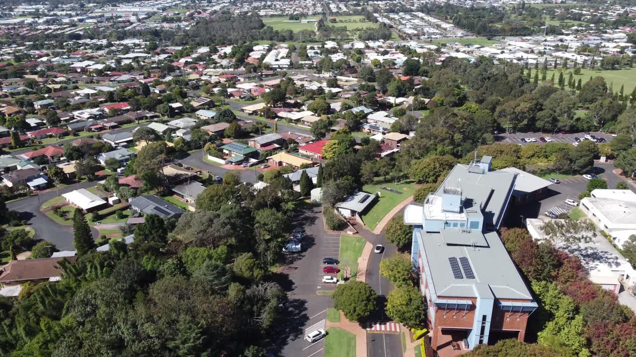 4K video of a drone flying over a commercial building towards a residential suburb in Toowoomba, Australia