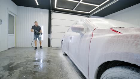 lavado de automóviles limpieza con espuma y agua a alta presión. coche rojo