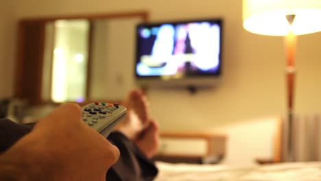 joven viendo la televisión en la habitación del hotel