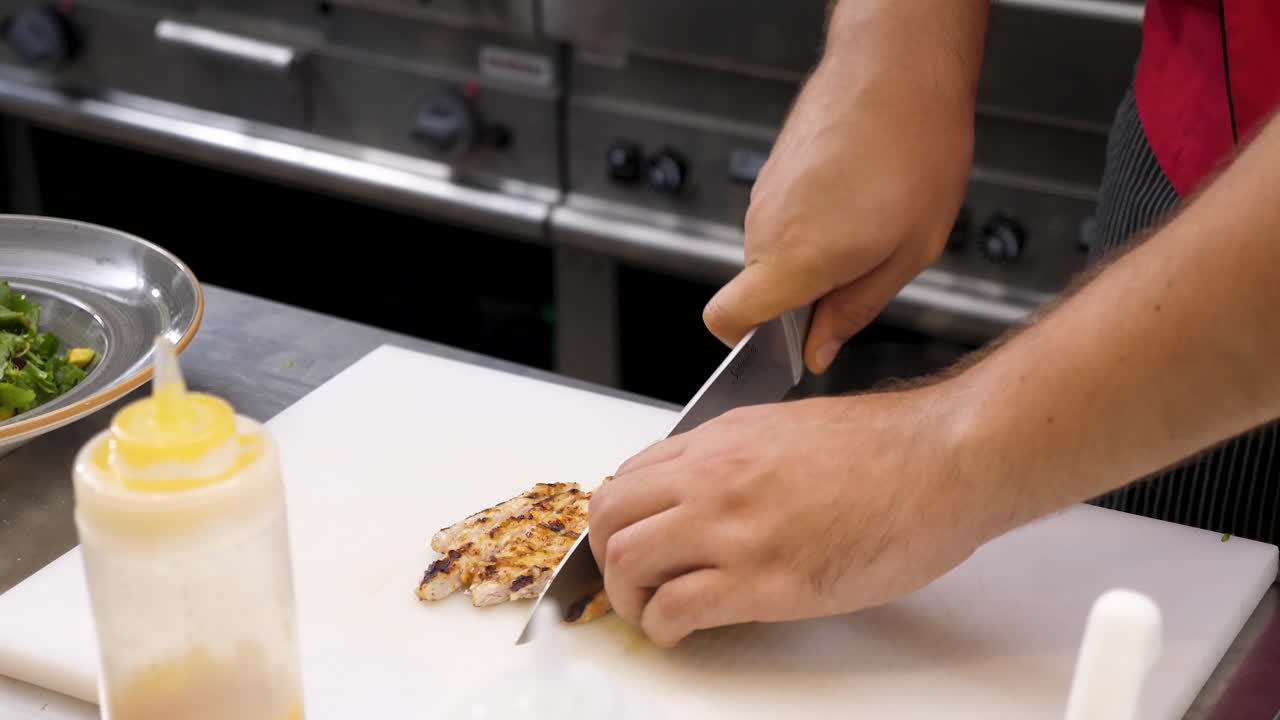 Chef Cutting Chicken in Restaurant Kitchen