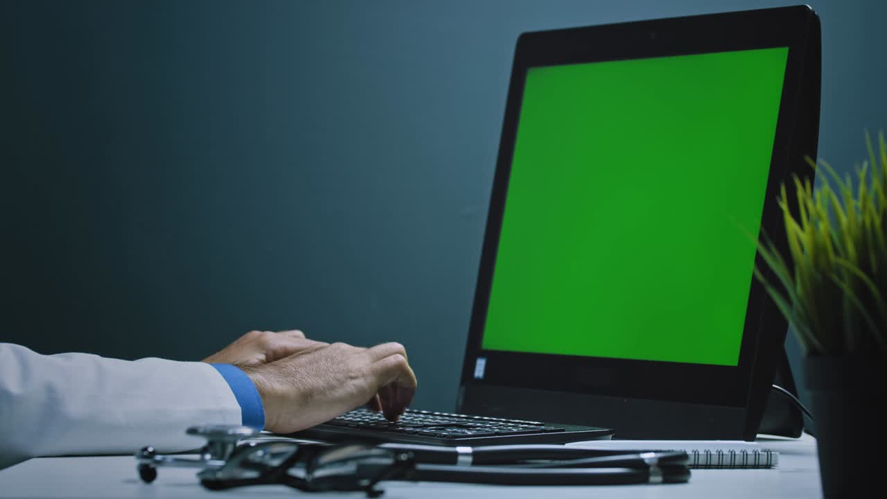 un médico trabajando en una pc con pantalla verde en un laboratorio modernamente equipado analizando la evolución del virus.