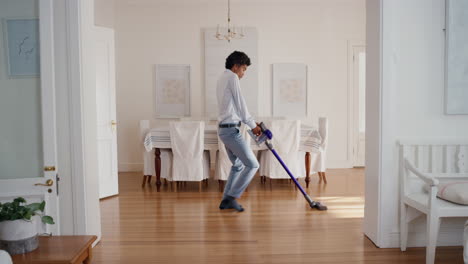 funny man dancing with vacuum cleaner at home celebrating success with weird victory dance moves having fun doing chores feeling successful 4k