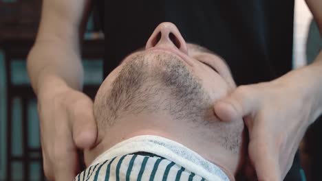 skin of young man is prepared for the design of a beard in a barber shop a close-up