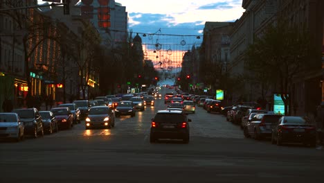 city street at dusk with traffic and pedestrians