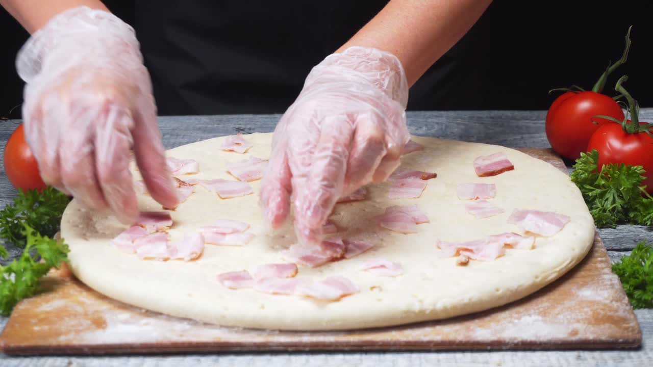 Preparazione di una pizza al bacon