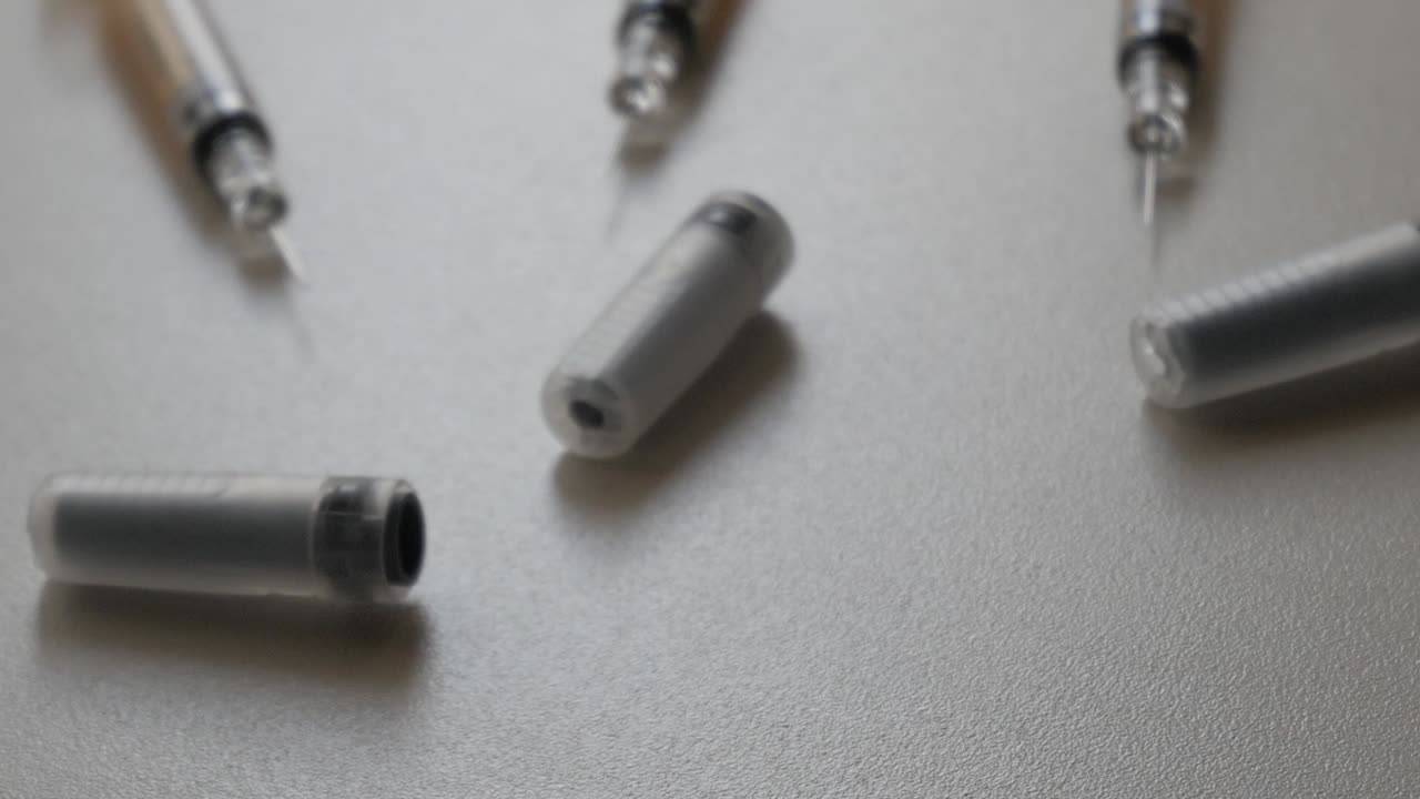 Dark cartridge tubes scattered on a light surface, minimalist design