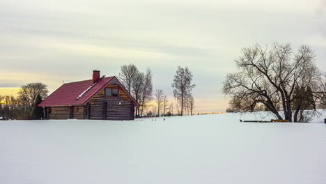 Zeitrafferaufnahme-Eines-Herrlichen-Sonnenaufgangs-Hinter-Wolken-In-Einer-Natürlichen-Verschneiten-Winterlandschaft-Mit-Haus