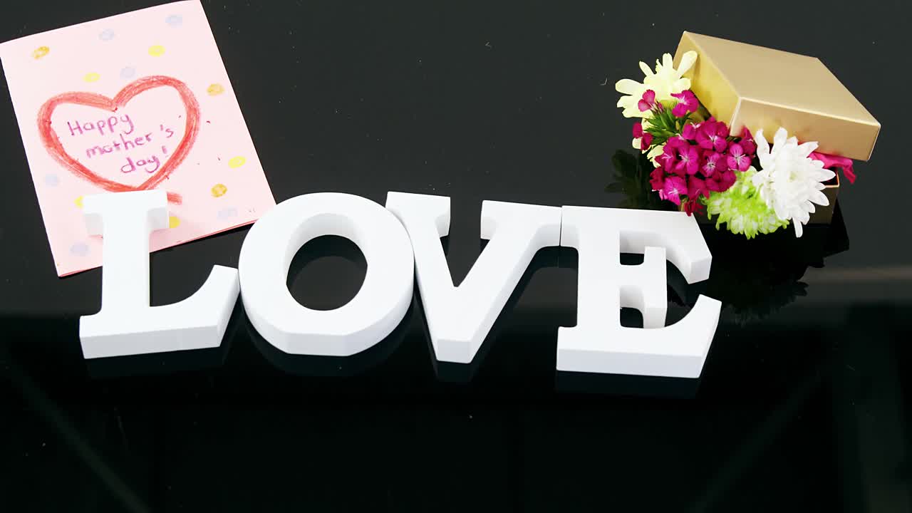 Greeting card, gift box and alphabet love on black background
