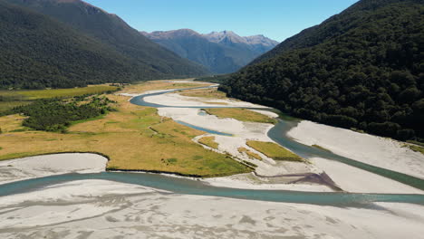 vista aerea panoramica dello splendido paesaggio della nuova zelanda nz con il fiume ruscello pulito acqua incontaminata che conduce alle montagne durante il cielo sereno tempo soleggiato