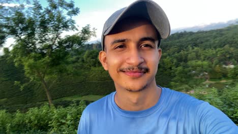 hombre viajero tomando video selfie en la naturaleza de la cima de la colina en la luz del sol de la mañana