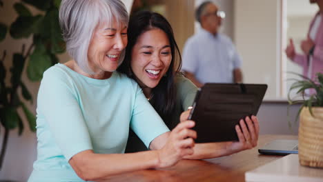 Smile,-senior-mother-and-daughter-on-tablet