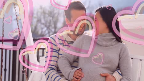 animación de iconos de corazón sobre un hombre caucásico feliz abrazando a su esposa embarazada