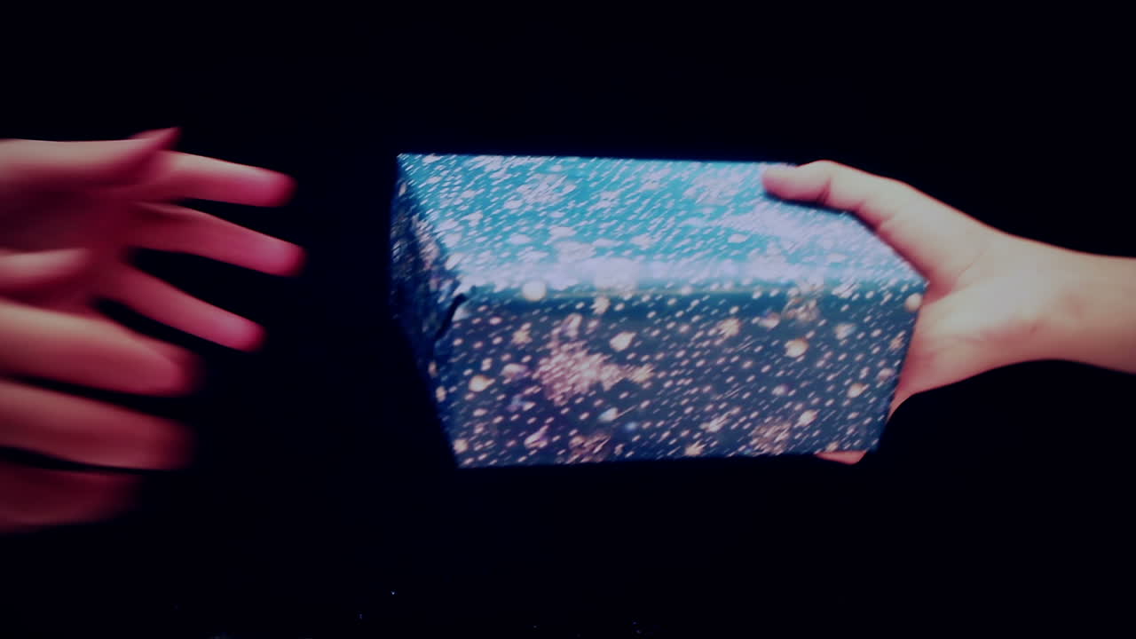 Close-Up of Hands Exchanging a Wrapped Gift Box