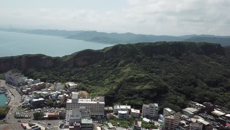 Panoramic-Aerial-View-on-Yehliu-City,-Fishing-Harbor-and-Forested-Hills,-Taiwan-Island-North-Coast