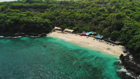dron descendente que vuela tierra adentro hasta la increíble playa secreta de arena blanca, playa bias tugel en bali