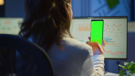 freelancer lookig en el teléfono móvil con pantalla verde