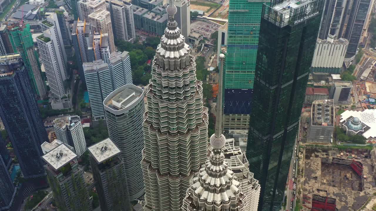 Aerial view drone fly around landmark KLCC Petronas Twin Towers capturing downtown cityscape of city center KL Kuala Lumpur, Malaysia