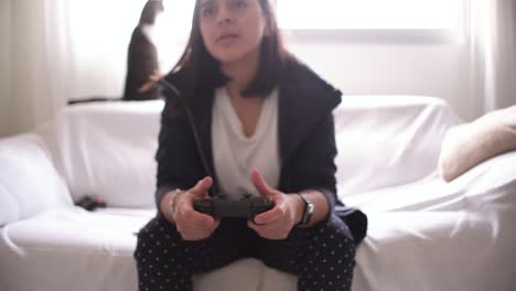 manos de mujer usando la vista de primer plano del gamepad jugando a la consola de video en casa sentada en el sofá