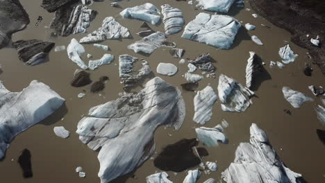 Icebergs-in-Muddy-Lake-Birdseye-Aerial