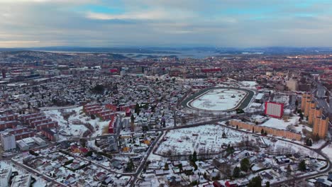 Oslo Fjord downtown cityscape Norge Norway aerial drone Gamle Tonsengagen Bjerke Arvoll morning buildings cars traffic highway roads snowing race track cold cloudy winter day gray skies circle right