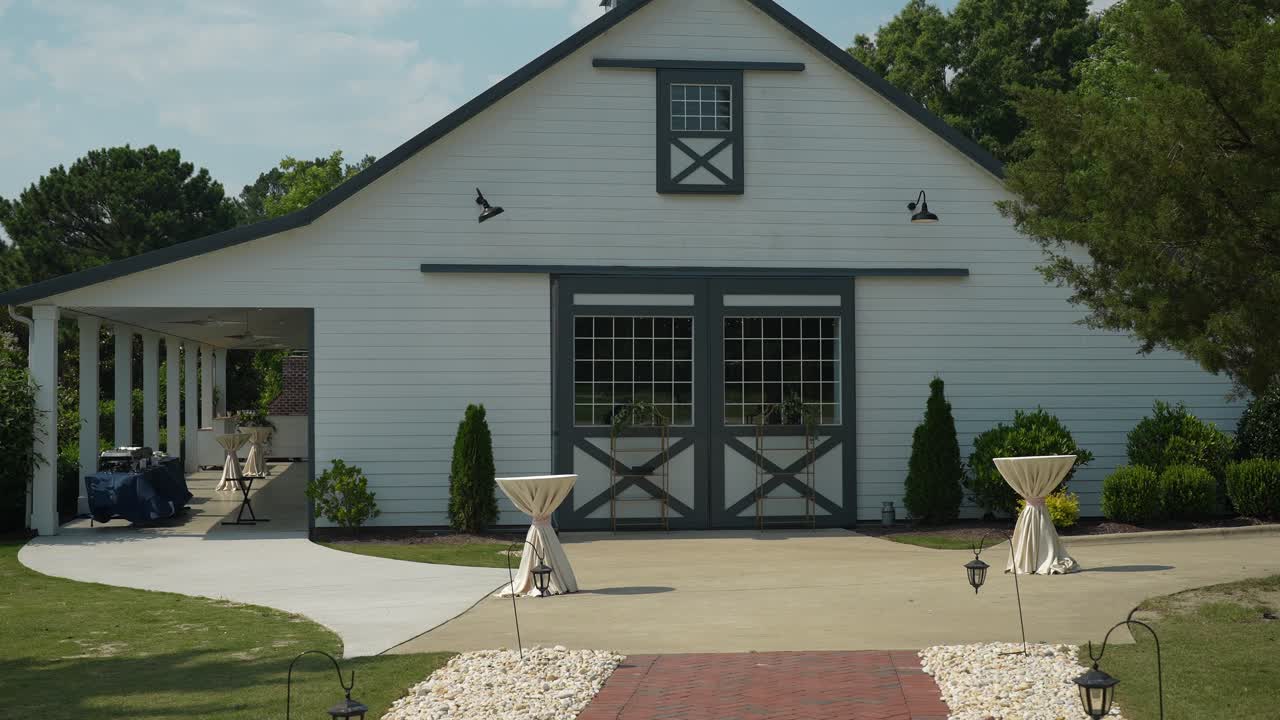 pintoresco granero blanco enmarcado por un encantador entorno natural de árboles