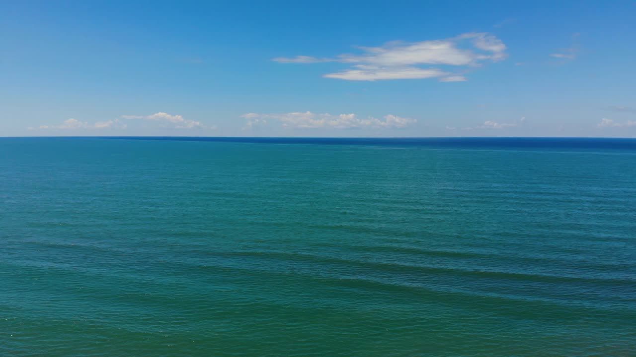 흰 구름과 밝은 하늘 아래 활기찬 깨끗한 물과 푸른 청록색 바다 질감